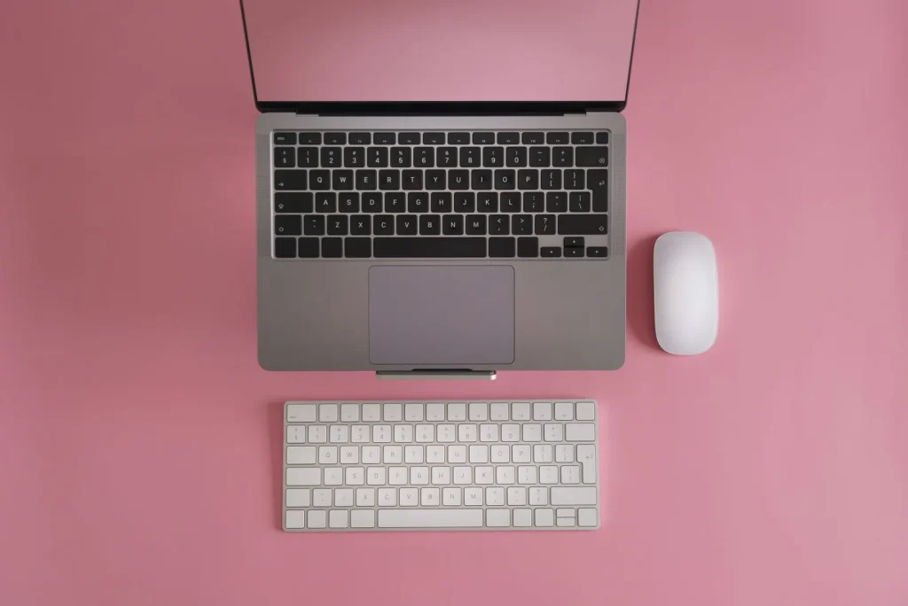 Notebook aberto sobre fundo rosa
